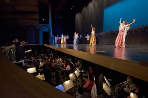 A view of the orchestra in the orchestra pit at Maumelle High School with dancers performing onstage