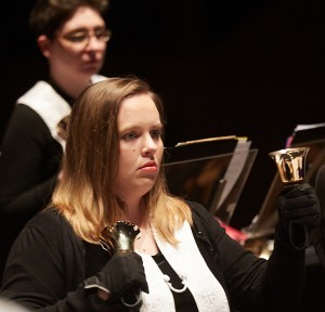 A photo of two women playing handbells